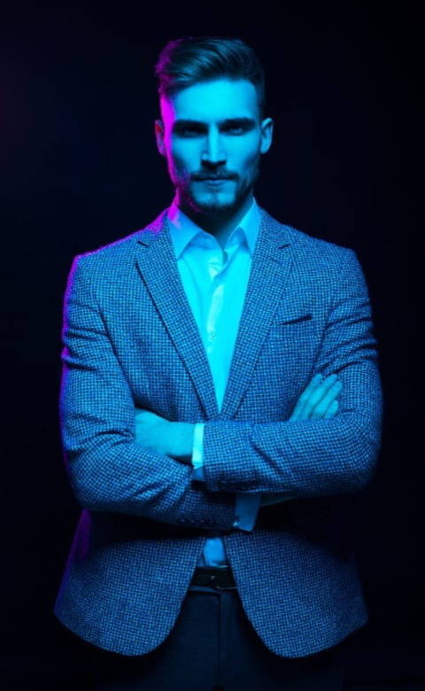 Focused man under blue light with crossed arms